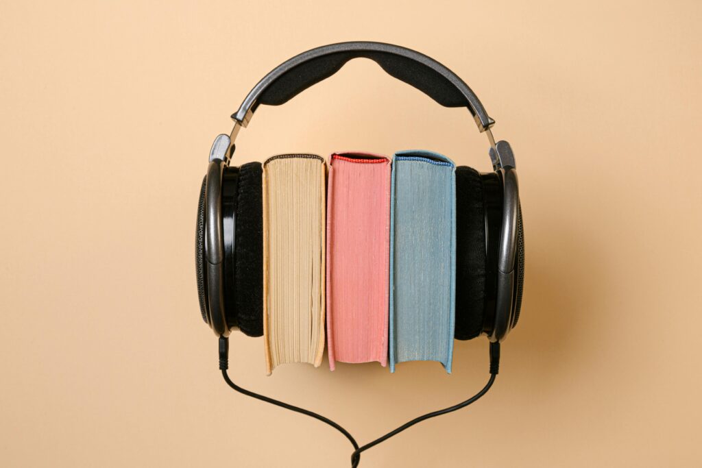 Stylish conceptual image of headphones and books on a beige background, symbolizing audiobooks.